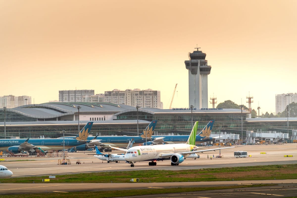 Tan Son Nhat International Airport in Ho Chi Minh City at dusk, Vietnam Airlines fleet at the terminal with the control tower behind